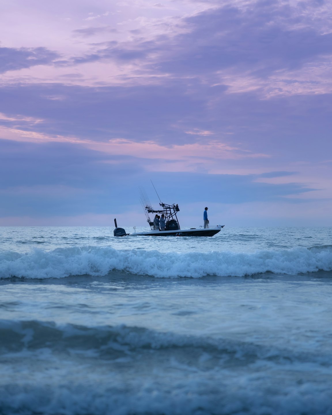 A group of people navigate a fishing boat on open water.